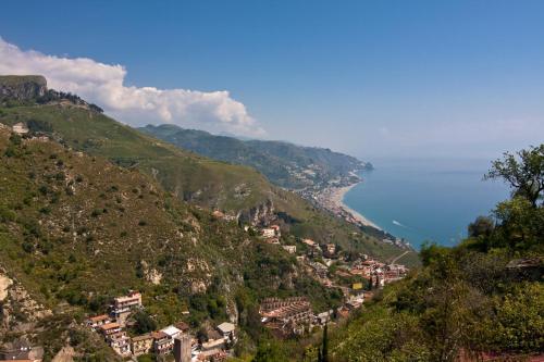 a town on a hill next to the ocean at B&B U Palmentu in Taormina