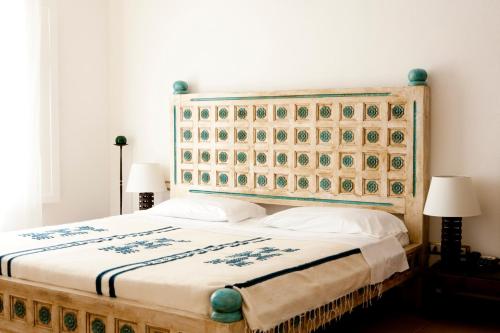 a bedroom with a large bed with a wooden headboard at Hotel Villa Pimpina in Carloforte