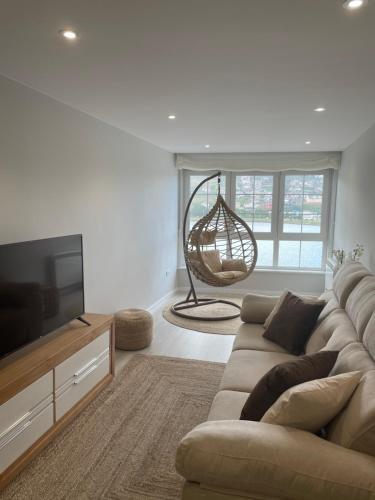a living room with a couch and a flat screen tv at Golden Views in Viveiro