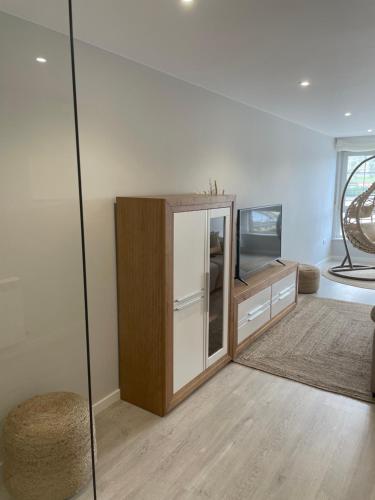 a living room with a cabinet and a tv at Golden Views in Viveiro