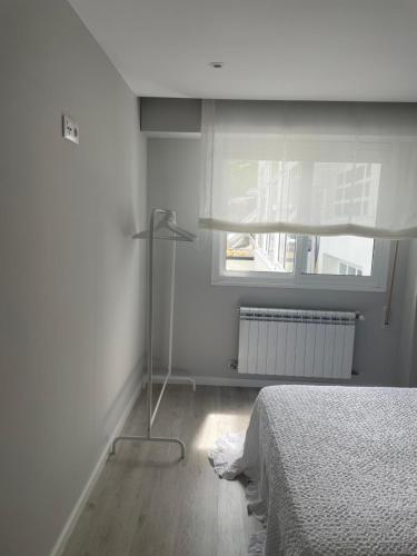 a white bedroom with a bed and a window at Golden Views in Viveiro
