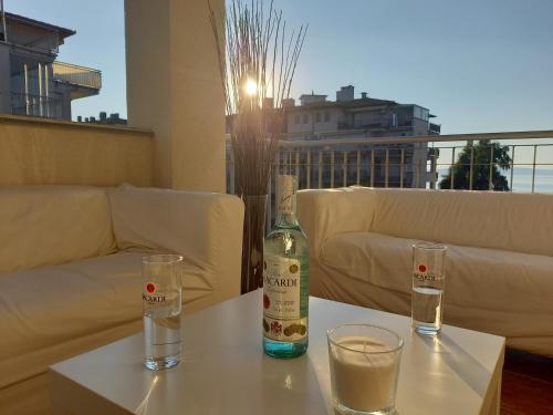a bottle of wine sitting on a table with two glasses at Balaton BeachSide Apartman Siófok N2 in Siófok