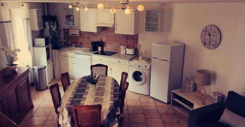 a kitchen with a table and a kitchen with white appliances at Gite Les Ours in Chémery