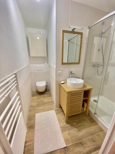 une salle de bain avec un lavabo, des toilettes et une douche dans l'établissement Capveo, à Pornichet
