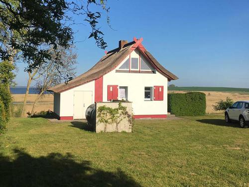 a red and white house with a car in front of it at Ferienhaus Grabowblick in Barth