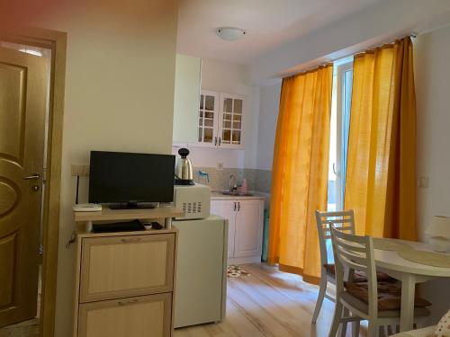 una cucina con televisore e tavolo con tavolo di Aphrodite Gardens D208, studio apartment a Sunny Beach