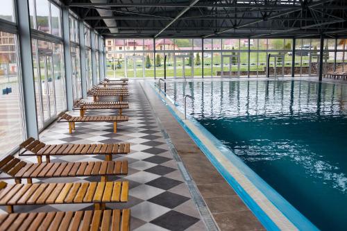 une rangée de bancs à côté d'une piscine dans l'établissement Termal Star Complex, à Nizhne Solotvyno