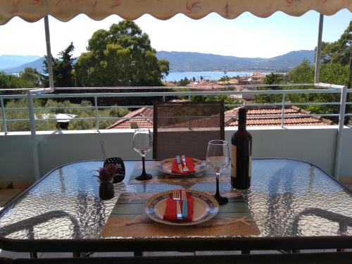 a table with two glasses and a bottle of wine at Valta's Room in Paleros