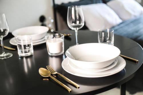 una mesa negra con platos, cucharas y vasos en Domeček / Tiny House, en Český Krumlov