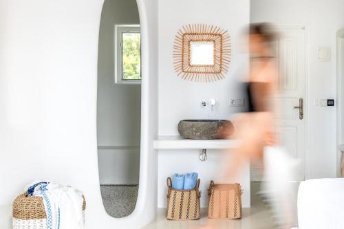 a person walking through a living room with a mirror at Evlalia Studios & Villas in Skopelos Town