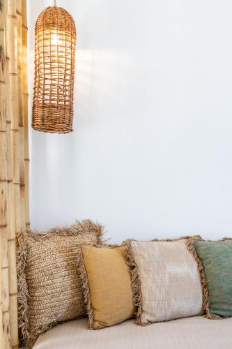 a bunch of pillows on a couch under a chandelier at Evlalia Studios & Villas in Skopelos Town