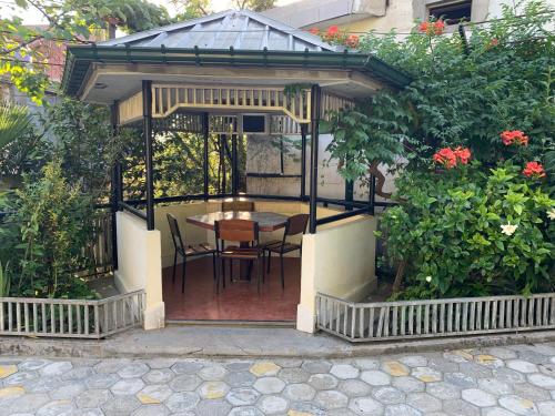 a gazebo with a table and chairs in it at Nargiz's Guest House in Batumi