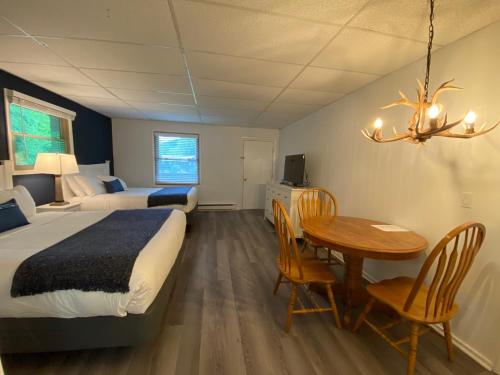 um quarto de hotel com uma cama, uma mesa e cadeiras em Catskill Seasons Inn em Shandaken