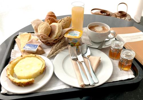 
a tray filled with sandwiches and a cup of coffee at Hotel Do Colegio in Ponta Delgada
