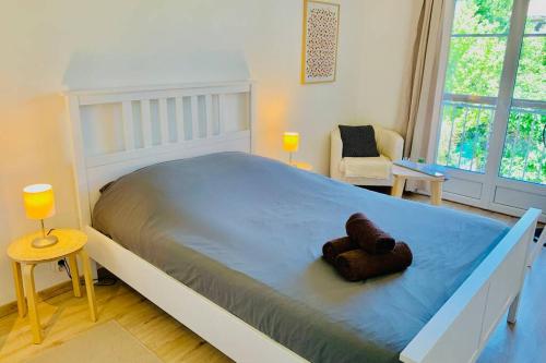 a bed with a teddy bear on it in a bedroom at PROVENCE APPARTEMENT in Manosque