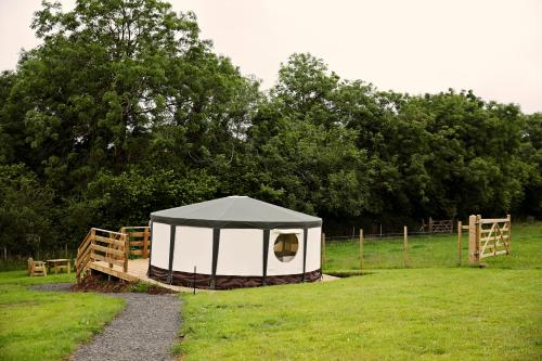 a black and white tent in a field at Little River Glamping in Ballymoney