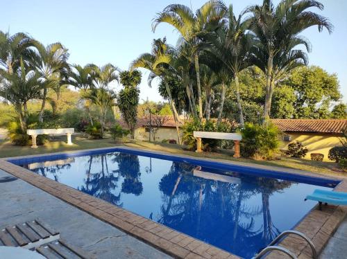 a swimming pool in a resort with palm trees at Pousada Boa Vista in Brotas