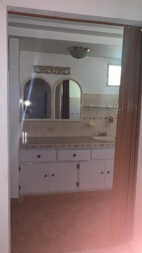 a bathroom with a sink and a large mirror at Hostal familiar Villa Nome in Penonomé