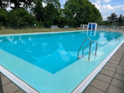 a large swimming pool with blue water at Ferienwohnung Unter den Linden in Halbe