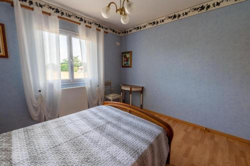 - une chambre bleue avec un lit et une fenêtre dans l'établissement Chambre privée de 12m² dans une maison toute équipée, à Aureilhan