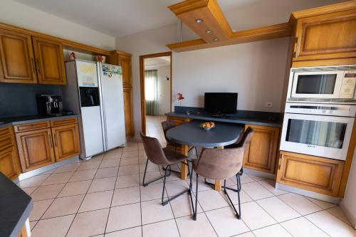 a kitchen with a table and chairs and a refrigerator at Chambre privée de 12m² dans une maison toute équipée in Aureilhan