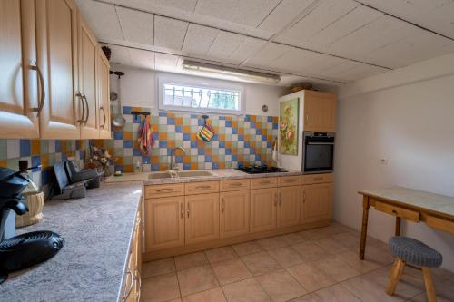 a large kitchen with wooden cabinets and a sink at Chambre privée de 12m² dans une maison toute équipée in Aureilhan