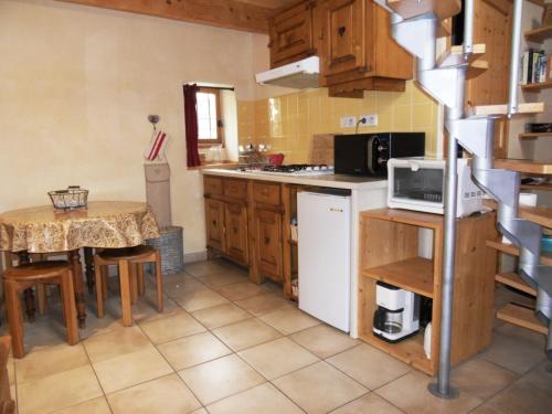 een keuken met een kleine tafel en een tafel en een keuken met een fornuis bij le Sarto - St Jean de Maurienne in Saint-Jean-de-Maurienne