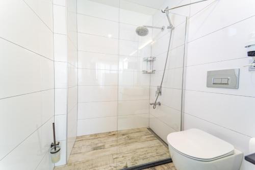 a white bathroom with a shower and a toilet at GREENBEACH HOTEL in Kalkan