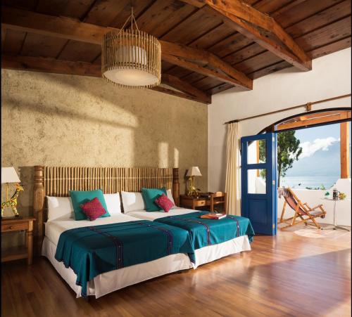 a bedroom with a large bed with green and white sheets at Villa Santa Catarina in Panajachel