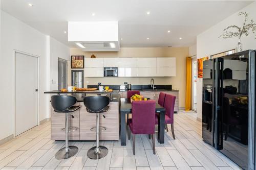 une cuisine avec une table et des chaises violettes dans l'établissement T3 moderne et cosy au bord de mer, à Marseille