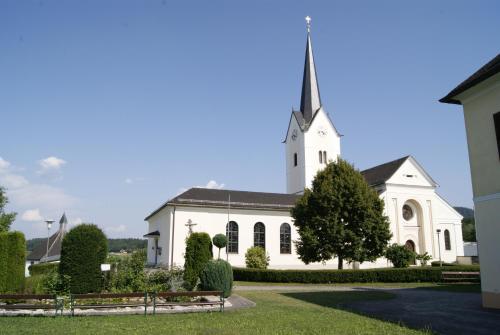 a white church with a steeple on top of it at Ferienwohnungen Gerti in Klopein am Klopeiner See