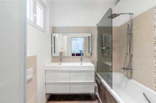une salle de bain blanche avec un lavabo et une douche dans l'établissement T3 moderne et cosy au bord de mer, à Marseille