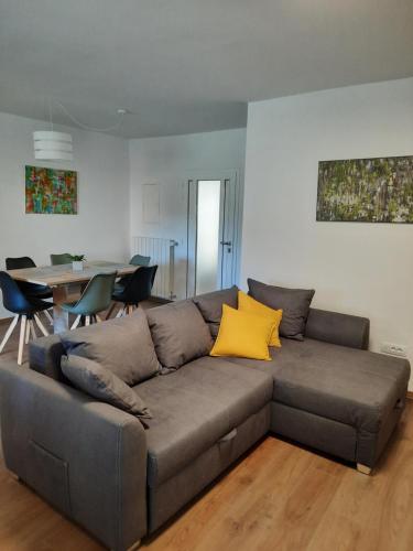 a living room with a gray couch with yellow pillows at Hiša Špuntar in Bovec