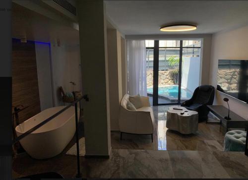 a living room with a tub and a couch and a table at daniela in Eilat