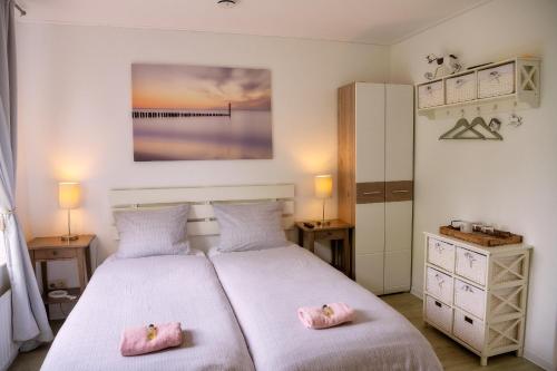 a bedroom with two beds with pink pillows at Het Zoete Pèèrd in Groede