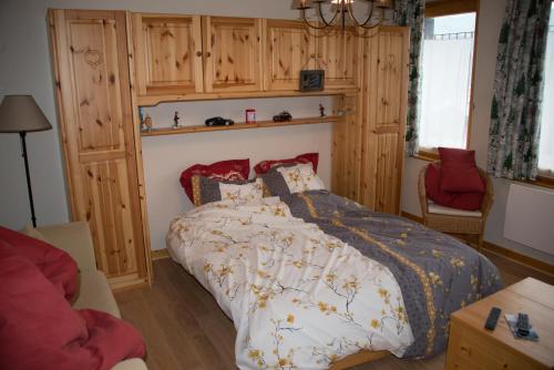 um quarto com uma cama e uma cadeira vermelha em Courchevel 1550 – VERITABLE SKI AUX PIEDS – APPARTEMENT LES TOVETS T2 – 47m2 – 4P em Courchevel