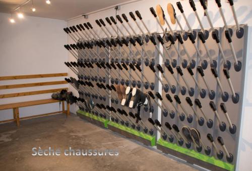 a wall filled with lots of baseball bats at Courchevel 1550 – VERITABLE SKI AUX PIEDS – APPARTEMENT LES TOVETS T2 – 47m2 – 4P in Courchevel