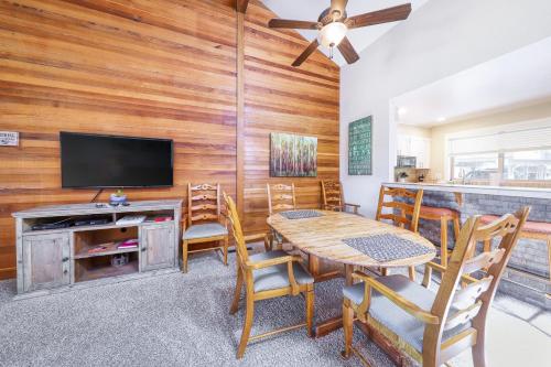 a dining room with a table and chairs and a flat screen tv at Quelah Condo 73 | Discover Sunriver in Sunriver