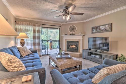 a living room with a blue couch and a tv at Waterfall/6th‑Floor View/Walk Downtown in Gatlinburg