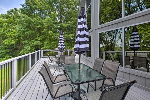 a deck with a table and chairs and an umbrella at Lake Cumberland Home with Deck and Water Access! in Monticello