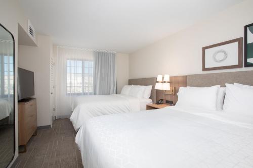 a hotel room with two beds and a television at Staybridge Suites - Carson City - Tahoe Area by IHG in Carson City