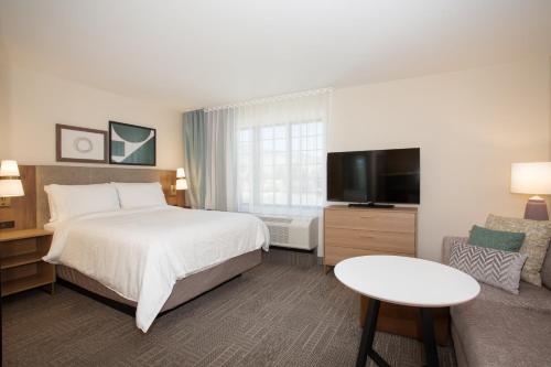 a hotel room with a bed and a tv and a couch at Staybridge Suites - Carson City - Tahoe Area by IHG in Carson City