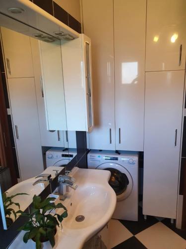 a bathroom with a sink and a washing machine at Hvar De Luxe Apartments in Hvar