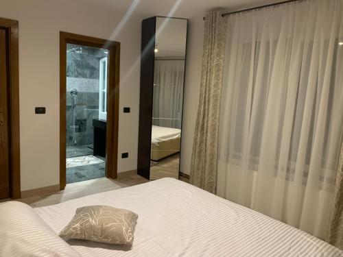 a bedroom with a bed with a pillow and a mirror at Villa Mery in Moisei