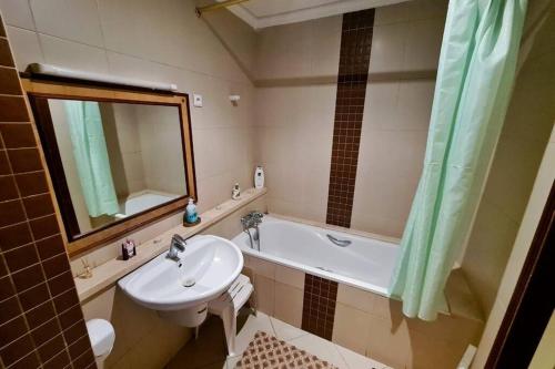 uma casa de banho com um lavatório, um WC e uma banheira em Appartement Haut Standing en plein centre ville em Agadir