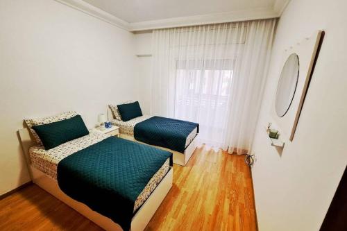 a bedroom with two beds and a window at Appartement Haut Standing en plein centre ville in Agadir