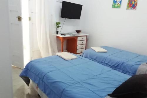 a room with two beds and a desk with a television at La Vega R. in Vega de Río de Palmas