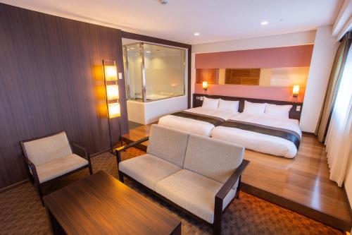 a hotel room with a bed and a table and chairs at Art Hotel Hirosaki City in Hirosaki