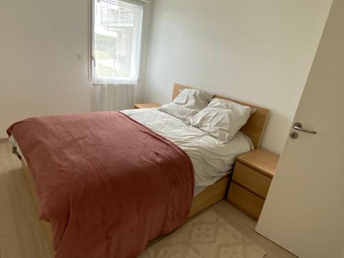 een bed in een kleine kamer met een raam bij LOGEMENT en rdc Port Haliguen in Quiberon