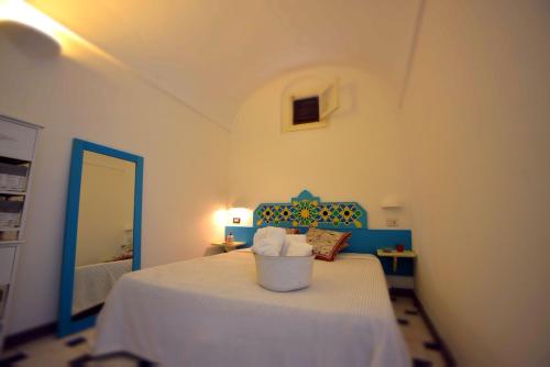 a bedroom with a bed with a blue headboard and a mirror at Dammusi al Tramonto in Pantelleria